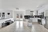 Kitchen with tasteful backsplash, a kitchen breakfast bar, appliances with stainless steel finishes, dark stone countertops, and white cabinets