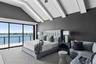 Bedroom with access to exterior, high vaulted ceiling, and a water view