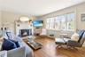 Living room featuring hardwood / wood-style flooring, a fireplace, and wainscoting
