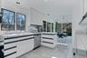 Kitchen with island and ample storage and above island cabinetry flanking dining areas for convenient serving