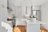 Kitchen featuring stainless steel appliances, a kitchen island, a sink, wood flooring, and wall chimney range hood