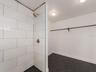 walk in shower with closet space in the back of the bath.