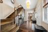 Inviting entrance foyer featuring rich hardwood flooring, a beautifully crafted staircase with classic wood balusters, and an open layout that creates