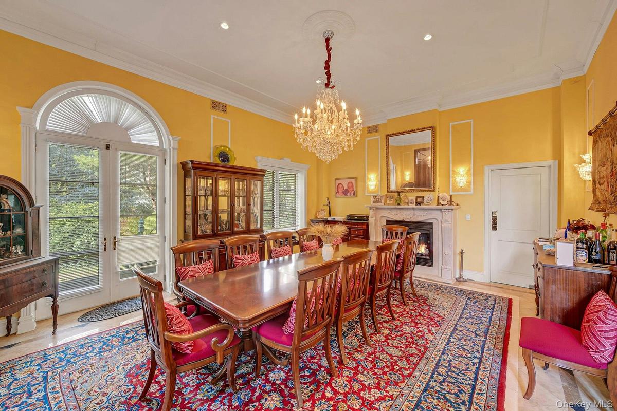 Dining room featuring a chandelier, crown molding, and a fireplace