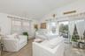 Living room featuring a baseboard heating unit, vaulted ceiling, and light wood-style flooring