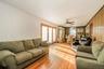 Open-concept living area with wood-finish flooring, white vertical paneled wall, and a wood-paneled accent wall