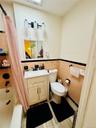 Bathroom featuring tile walls, toilet, a wainscoted wall, vanity, and shower / bath combo