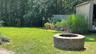 View of yard featuring an outdoor fire pit and fence
