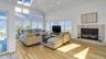 Living area with a tiled fireplace, recessed lighting, a skylight, light wood-style floors, and high vaulted ceiling