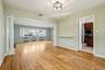 Unfurnished living room with decorative columns, light wood-type flooring, and radiator