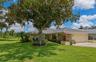 Front of home with shade tree and golf course beyond