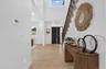 Double-height entryway with recessed lighting, wood-finish flooring, and a staircase featuring a wrought iron railing