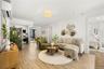 Living room featuring light wood-style floors and an AC wall unit