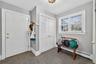 Foyer entrance featuring a baseboard radiator and dark stone finish flooring