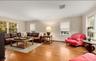 Living room featuring crown molding, wood finished floors, and a baseboard heating unit