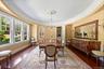 Dining room with dark wood finished floors, a chandelier, and built in shelves