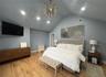 Bedroom with an inviting chandelier, vaulted ceiling, and light hardwood / wood-style floors