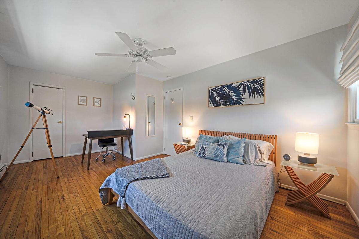 Bedroom with a ceiling fan, baseboards, and wood-type flooring