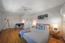 Bedroom with a ceiling fan, baseboards, and wood-type flooring