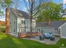 Back of property featuring a patio, an outdoor living space, a chimney, and a lawn
