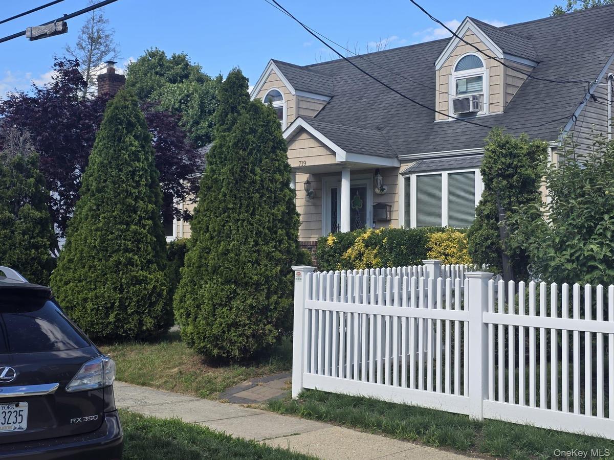 Traditional residence featuring dormer windows, a bay window, and a white picket fence