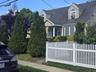 Traditional residence featuring dormer windows, a bay window, and a white picket fence