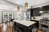 Stunning gourmet kitchen featuring custom cabinetry, quartz countertops, a large center island with seating, and premium stainless steel appliances, i