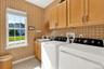 Separate laundry room with utility sink and storage cabinetry