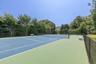 Private tennis court with regulation net and perimeter fencing