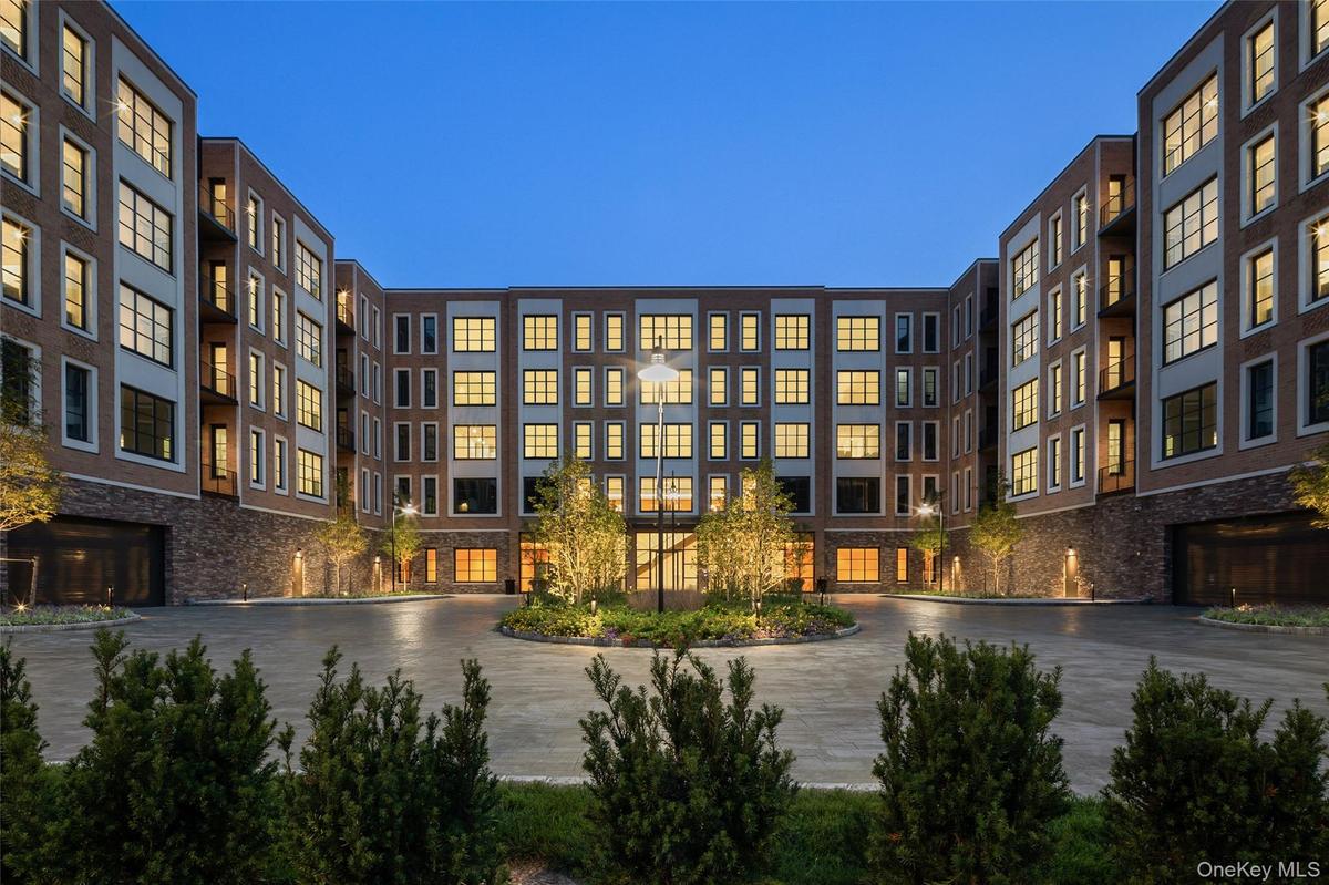 A captivating twilight shot showcases the building's front facade glowing warmly as day transitions to night.
