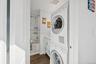 Washroom featuring dark wood finished floors and estacked washer and dryer