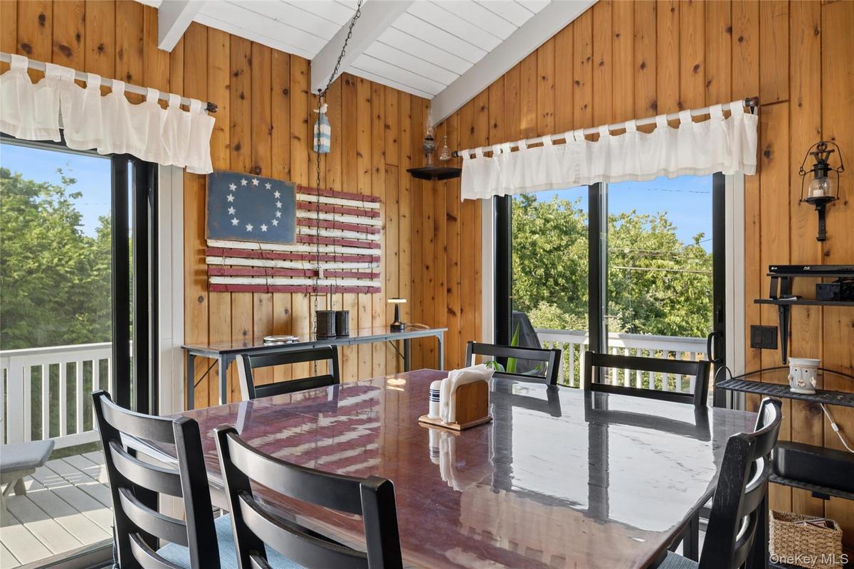 Dining area featuring extensive wood paneling and a vaulted ceiling