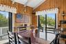 Dining area featuring extensive wood paneling and a vaulted ceiling