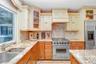 Viking Range and split stainless steel sink and decorative tile backsplash.