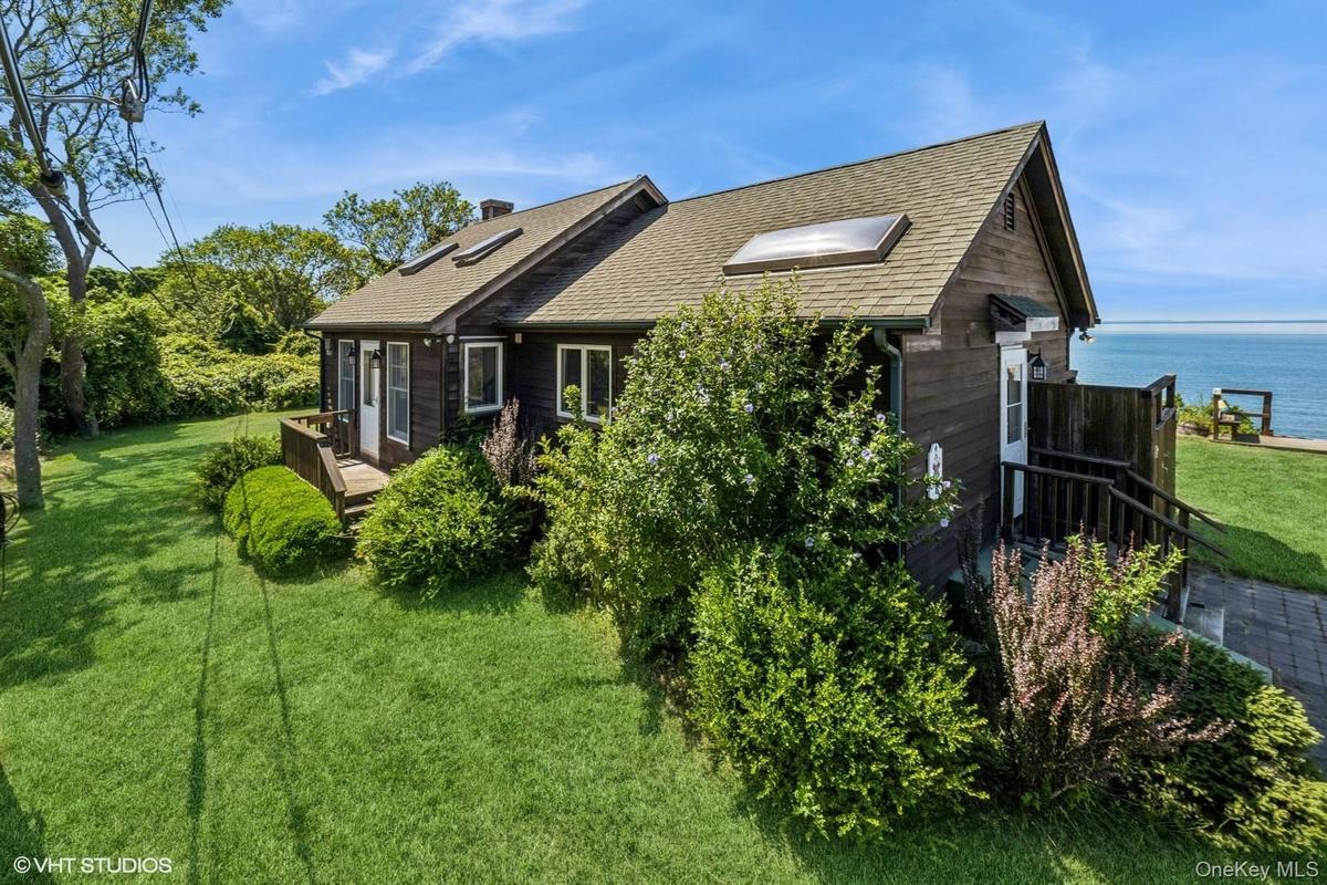 View of home's exterior with a yard, a shingled roof, and a chimney