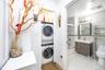 Laundry room with stacked washing machine and dryer and light wood-type flooring