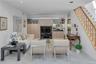 Recessed lighting illuminates this living space featuring light wood-finish built-in cabinetry, a built-in bar area with a mirrored backsplash, and a