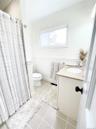 Bathroom featuring vanity, a wainscoted wall, light tile patterned floors, and curtained shower