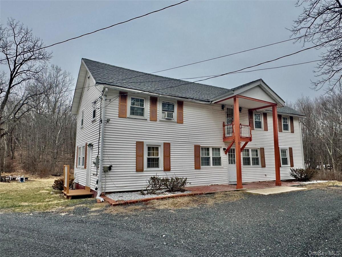 1 - View of front of property featuring a balcony and a shingled roof