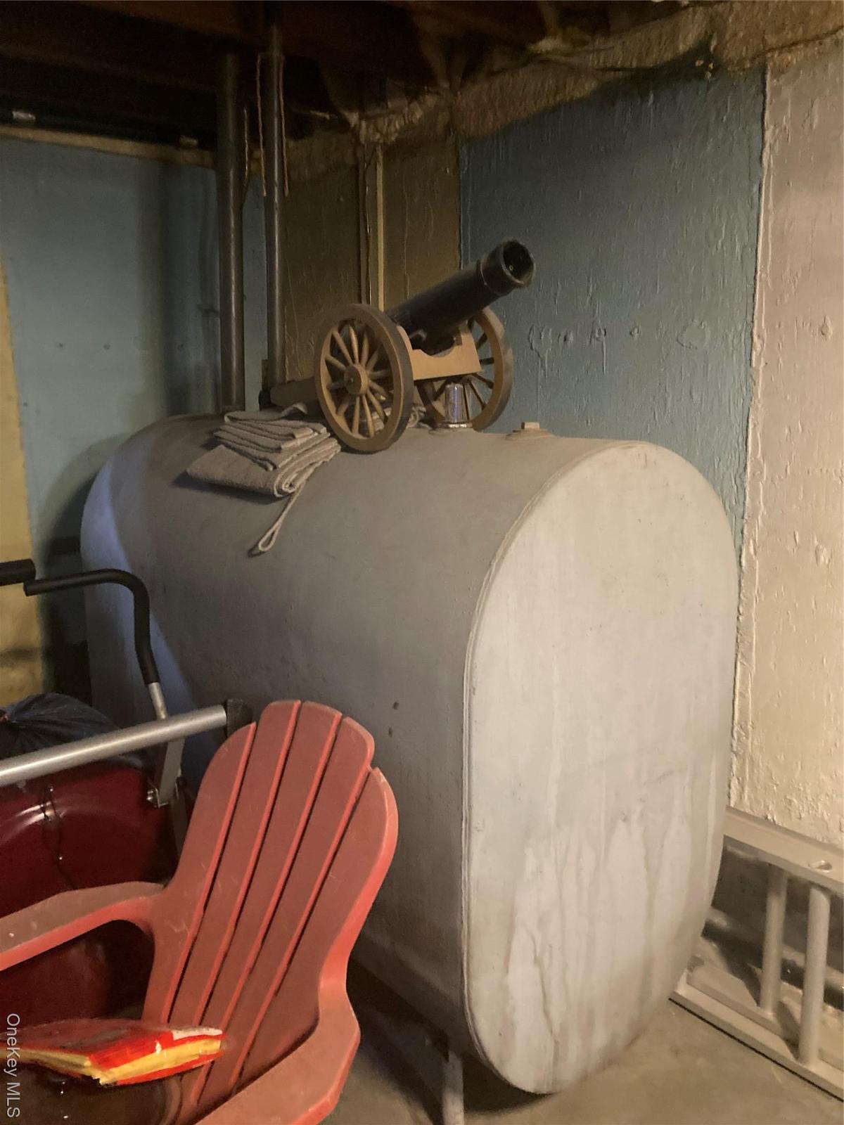 Basement view of heating fuel, a textured wall, and unfinished concrete floors