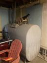 Basement view of heating fuel, a textured wall, and unfinished concrete floors