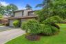 Exterior featuring a sloped roofline, attached garage, and a paved driveway