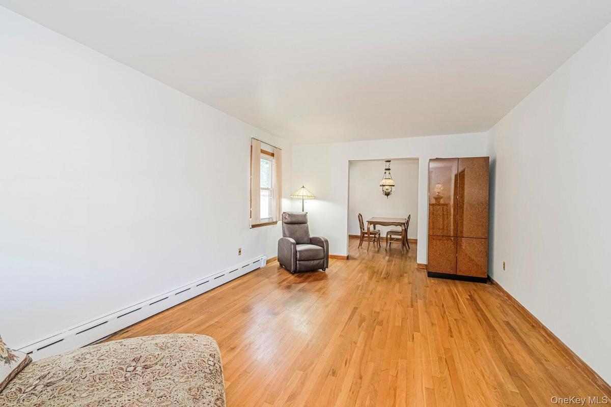 Hardwood flooring throughout, offering a bright interior with white walls and a visible window