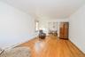 Hardwood flooring throughout, offering a bright interior with white walls and a visible window