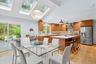 Dining space featuring light wood-style flooring, a skylight, beam ceiling, and high vaulted ceiling