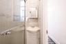 Bathroom featuring a stall shower, vanity, and tile walls
