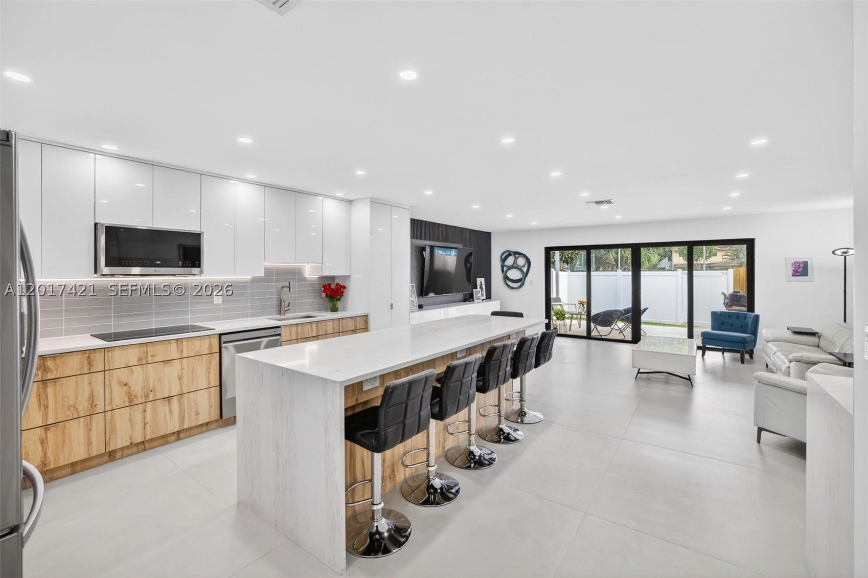 WOW! Beautiful porcelain flooring, huge center island w/ waterfall quartz counter & counter seating.