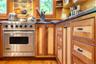 Kitchen featuring brown cabinets, high end stainless steel range oven, and open shelves