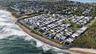 View of property location with expansive beach and nearby suburban area