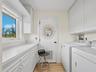 Convenient laundry room with folding and storage space.